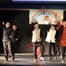 Group of students on stage performing a bhangra dance