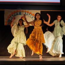 Group of students on stage performing a bhangra dance