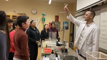 Summer School 2023 - Chemistry 11 Students watch as teacher demonstrates a chemistry lab