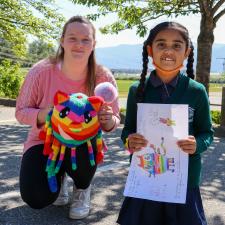 Female secondary student and female elementary student show the stuffy and artwork