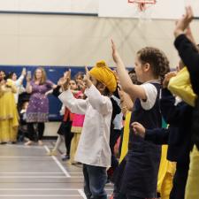 Elementary students performing a Bhangra dance as the rest of the school joins